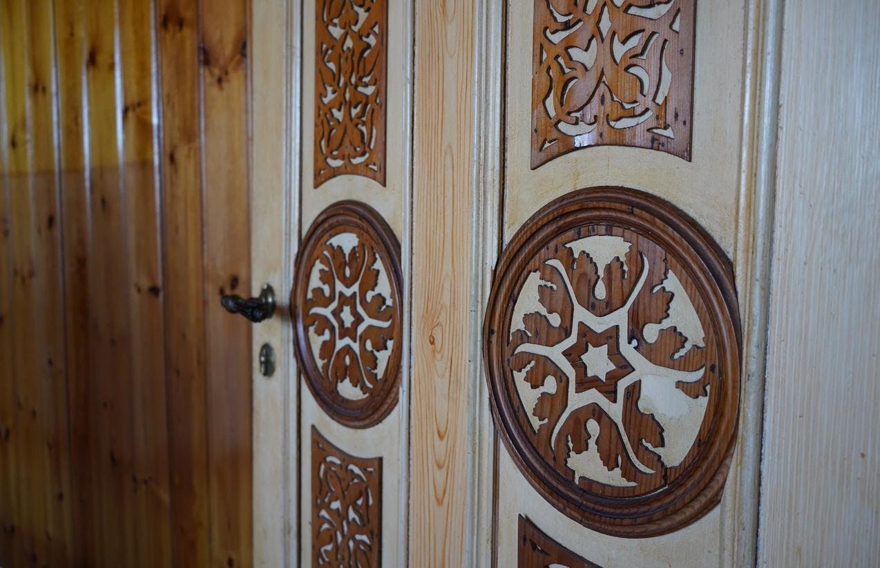 En dør i villaen på Lysøen, med mørkbrune ornamenter på en lysbrun dør