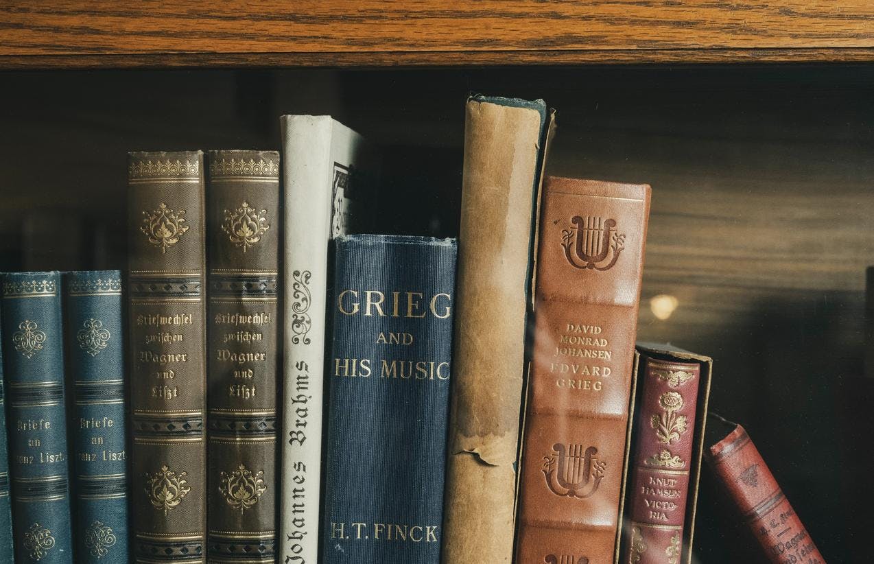 Et utvalg eldre bøker som står i en bokhylle i Griegs villa