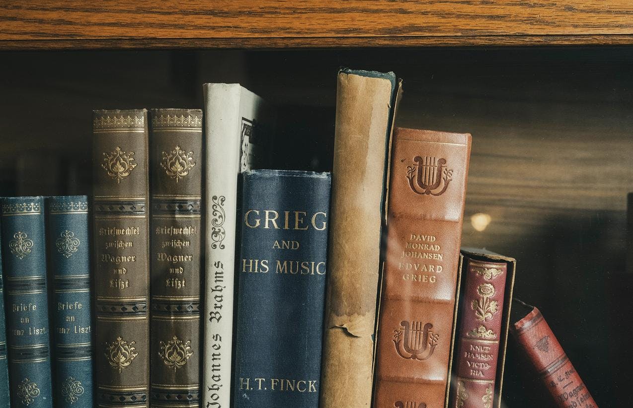 En rekke bøker, en av dem med tittelen Grieg and his music, i en bokhylle i Griegs villa