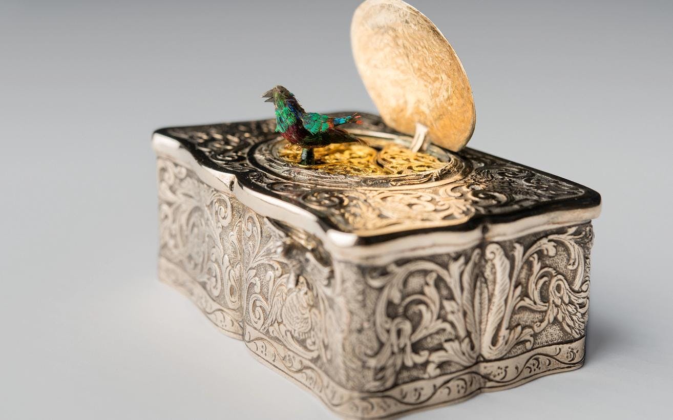En spilledåse i delvis forgylt sølv, med en liten fugl på lokket